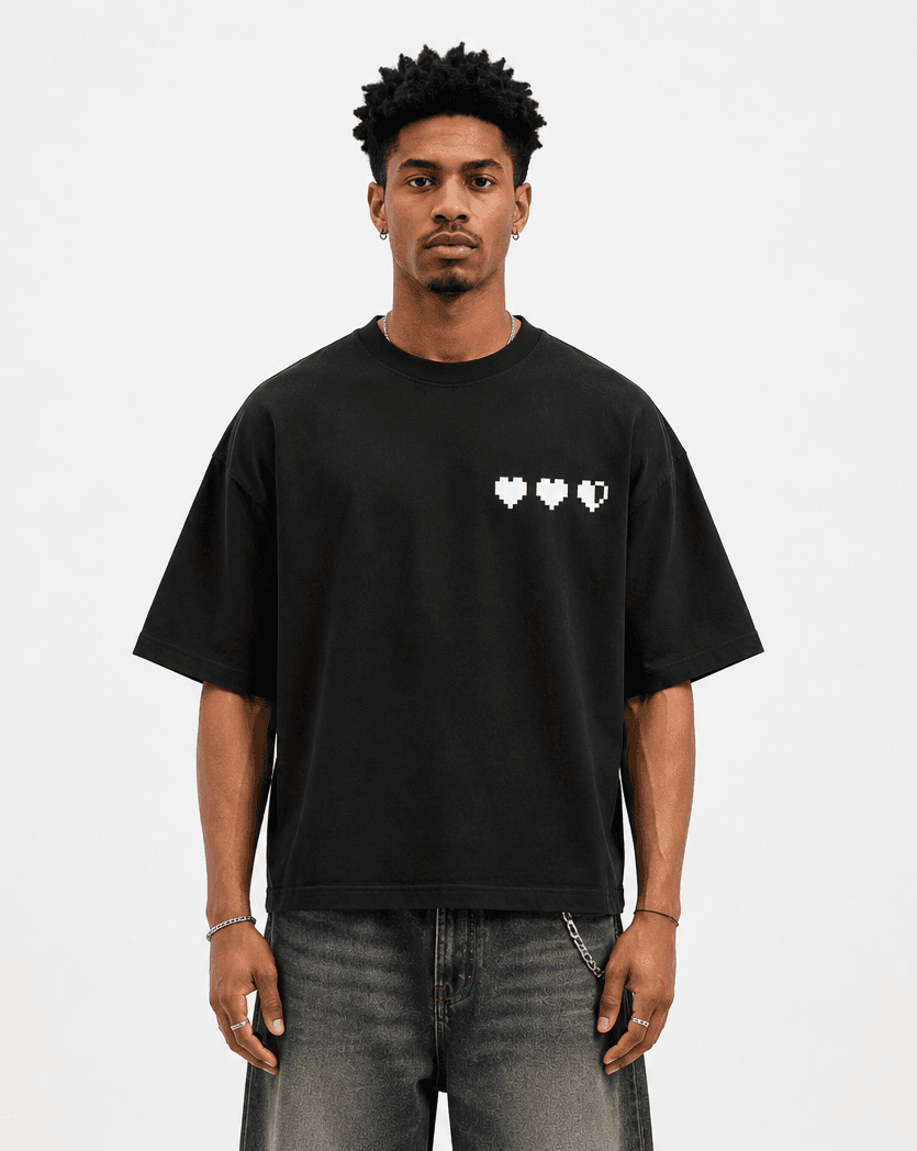 Model wearing the black Game Over Oversized Tee with three pixel hearts printed on the chest