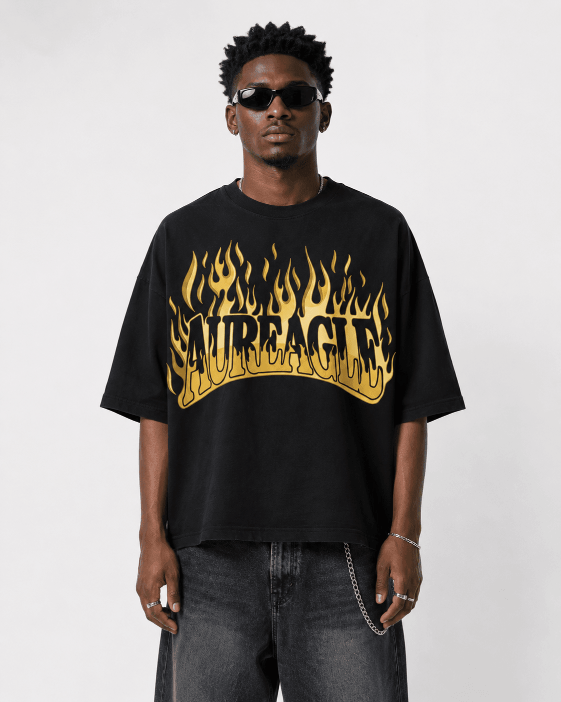 Model wearing the black Ignite Oversized Tee with the gold flame AUREAGLE chest print