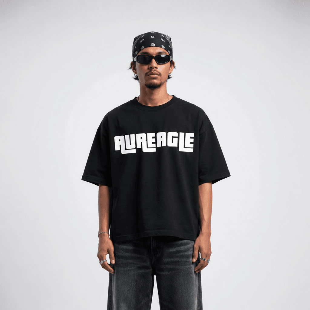 Model wearing the black Crew Oversized Tee with the arcade-style AUREAGLE chest print