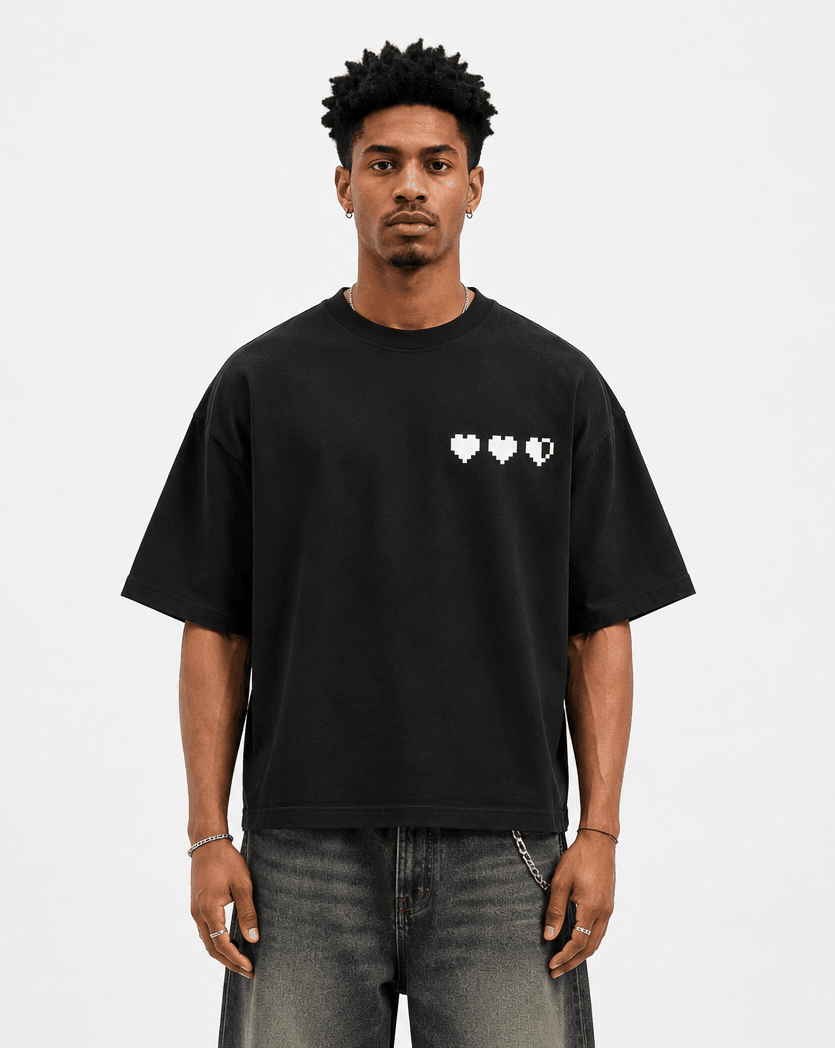Model wearing the black Game Over Oversized Tee with three pixel hearts printed on the chest