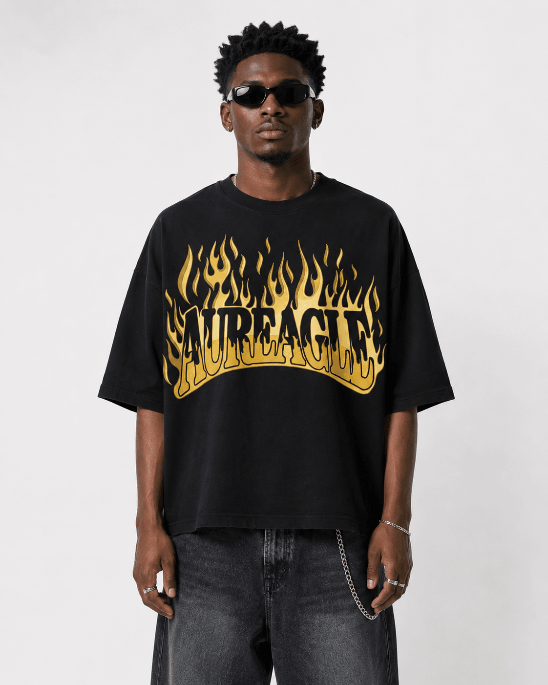 Model wearing the black Ignite Oversized Tee with the gold flame AUREAGLE chest print